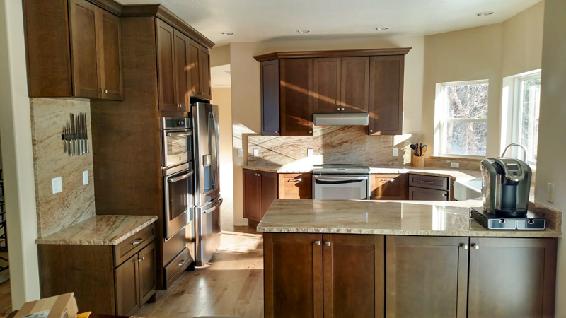 Dark stained cabinet kitchen with stone backsplash in Coeur d'Alene, Idaho