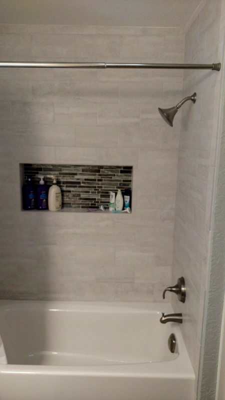 Gray tile tub surround with mosaic niche in Rathdrum, Idaho