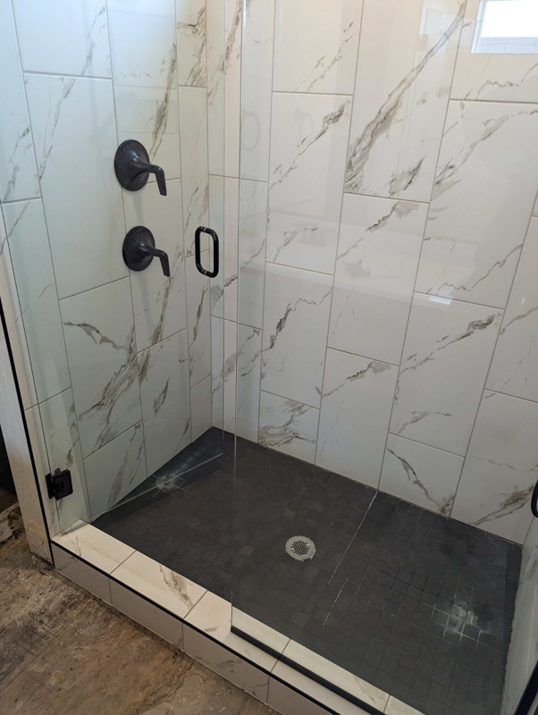 Marble glass-door shower with black fixtures in Dalton Gardens, Idaho